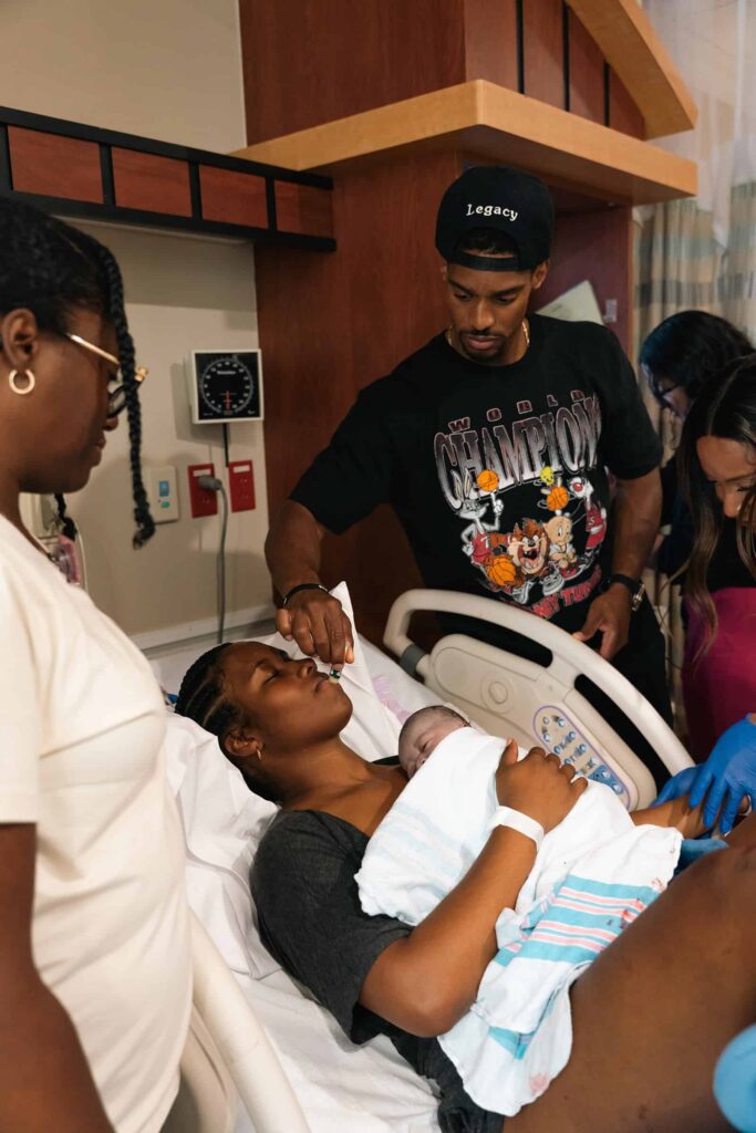 Birth photography session in Murfreesboro, Tennessee showing parents with their newborn and hospital staff
